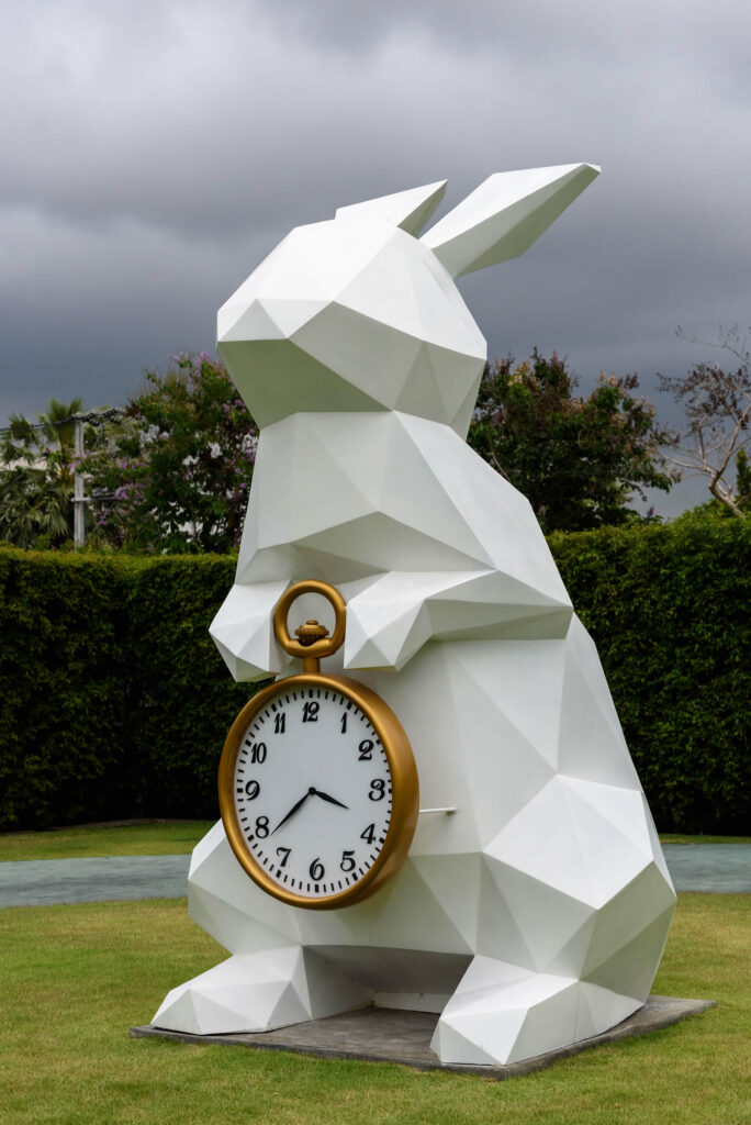 White rabbit holding gold frame pocket watch